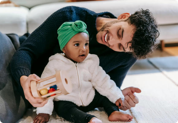 adult male talking and playing toys with a one and half year old child