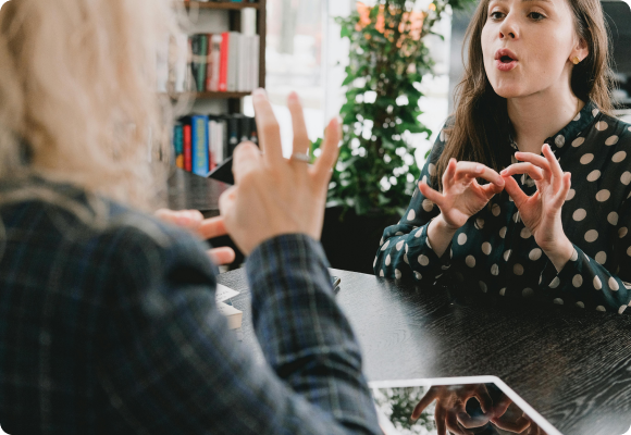 speech therapy session of two women using hand gestures